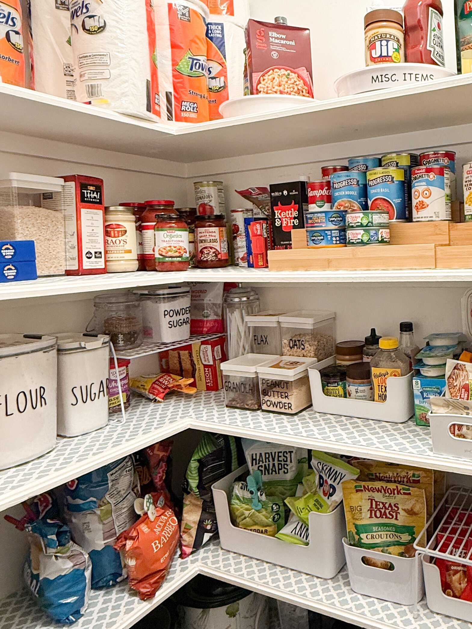 Pantry Organizing with neutral pantry organizer staples featuring oatmeal, pasta, and snack containers with can storage. 