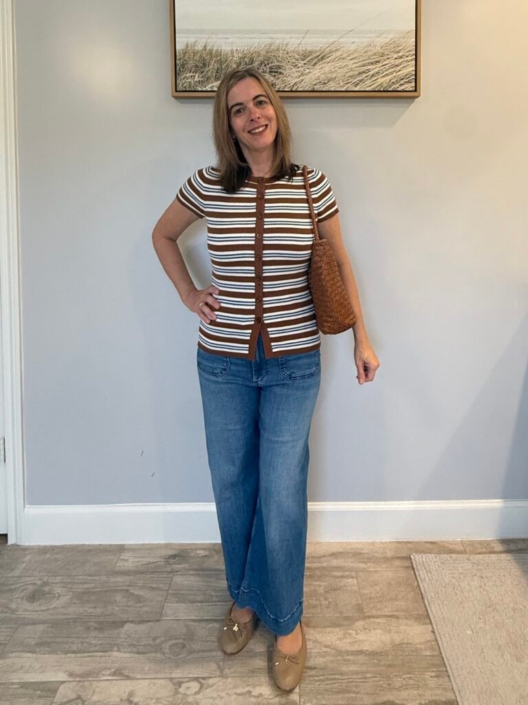 How to wear a cardigan with style: Women wearing a button up cardigan with dark jeans, ballet flat shoes, and a brown woven shoulder handbag.