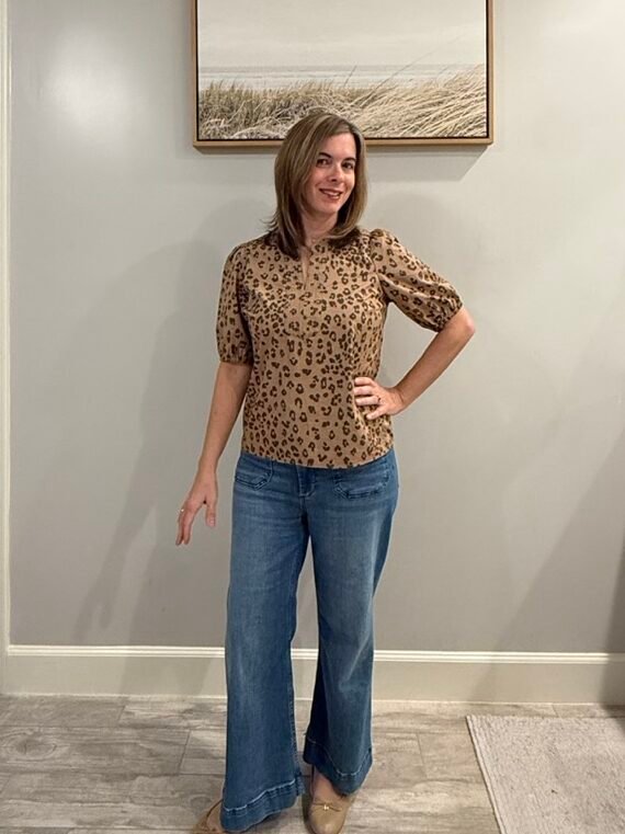 Women wearing short-sleeve leopard top with puff sleeves, wide leg jeans and ballet flat shoes.