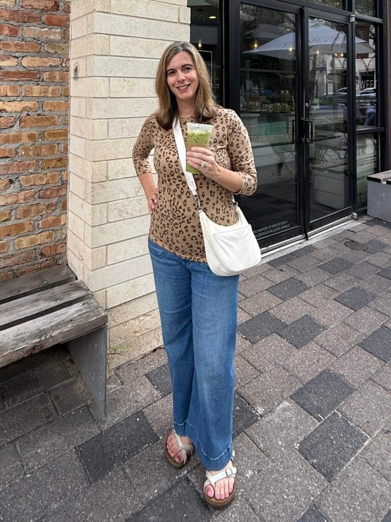 Women wearing leopard top, wide leg jeans and Birkenstock sandals.