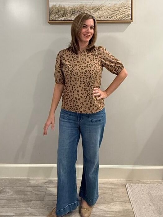 Women wearing leopard top with puff sleeves, wide leg jeans and ballet flat shoes.
