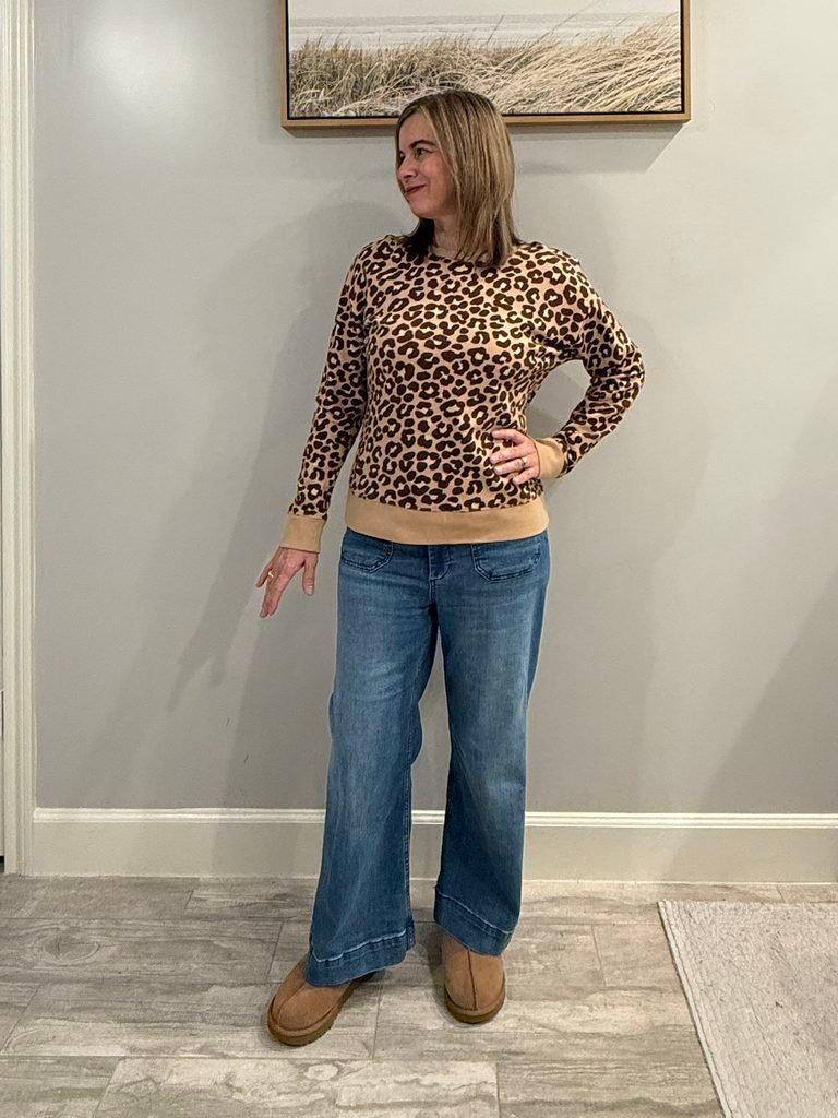 Women wearing leopard sweatshirt, wide leg jeans and Ugg slip-on shoes.