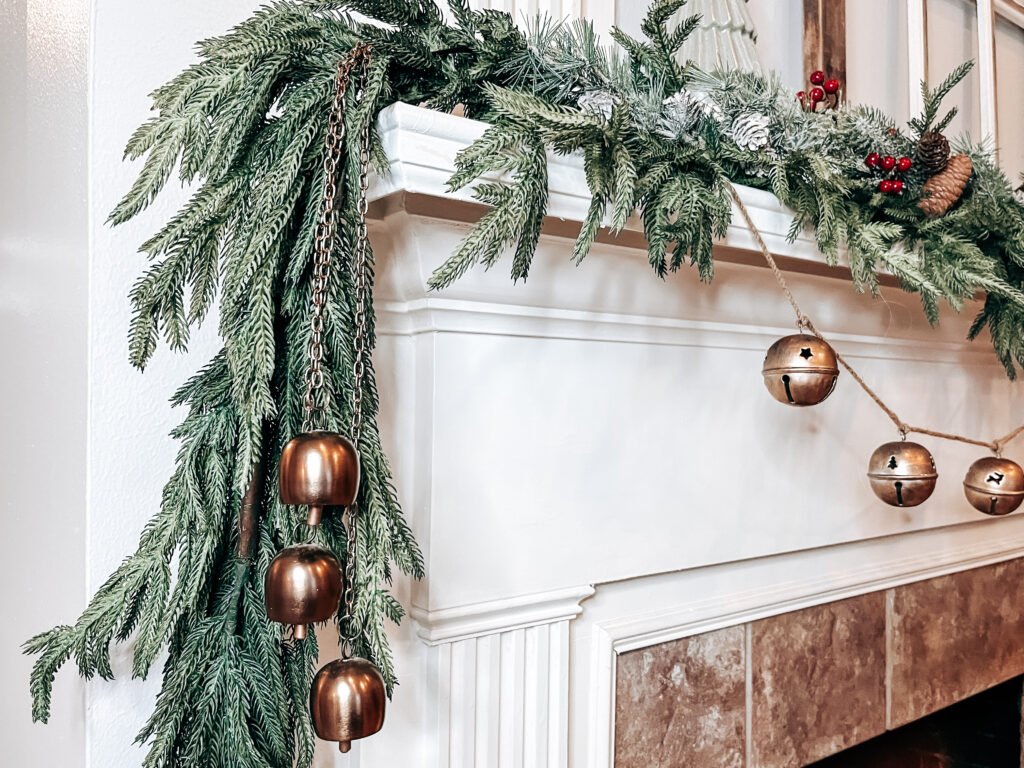 cozy Christmas mantel with garland, and vintage look gold bells