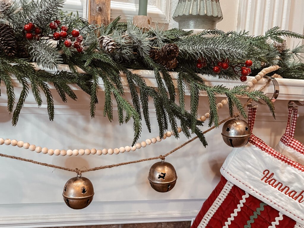 frosted greenery and pinecone picks layered across mantel garland